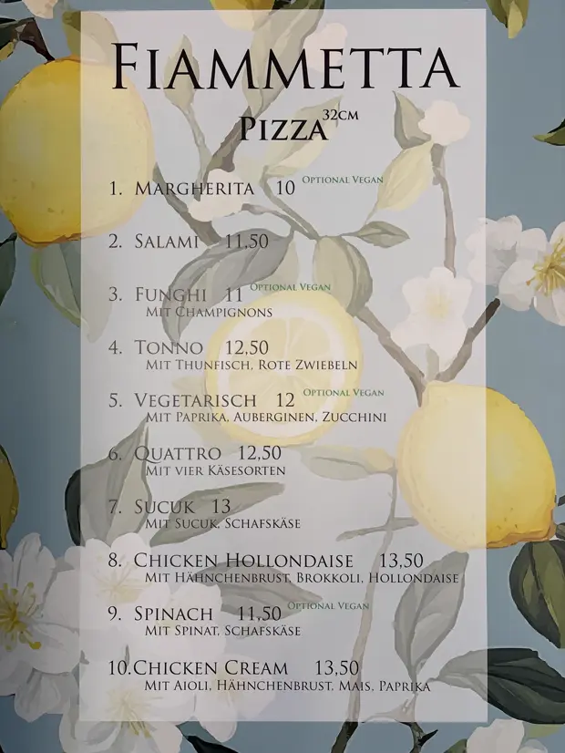 Die Pizzakarte im Laden: FIAMMETTA in Versalien auf Zitronen-Tapete, zehn Pizzen mit Preisen.